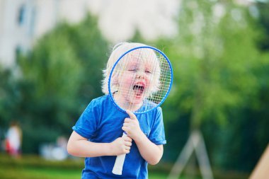 Küçük çocuk parkta badminton oynarken