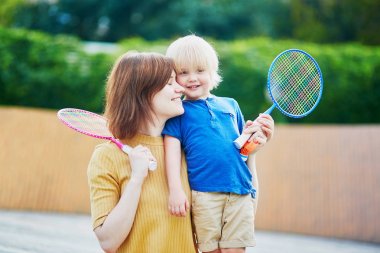 Küçük çocuk anne ile badminton oyun oynamaya