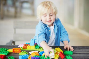 Küçük çocuk renkli plastik inşaat bloklarla oynama