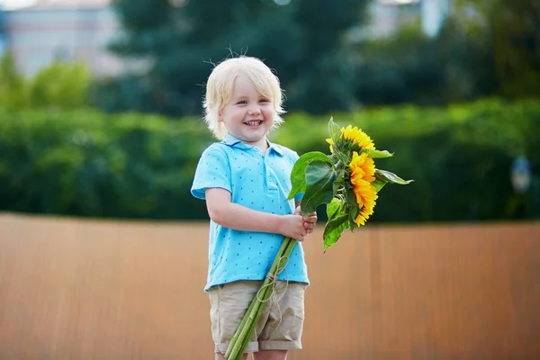 Kleiner Junge mit Sonnenblumenstrauß im Freien — Stockfoto