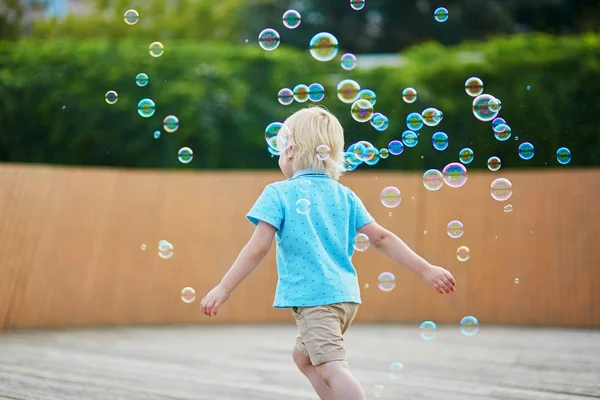 Menino brincando com bolhas ao ar livre — Fotografia de Stock