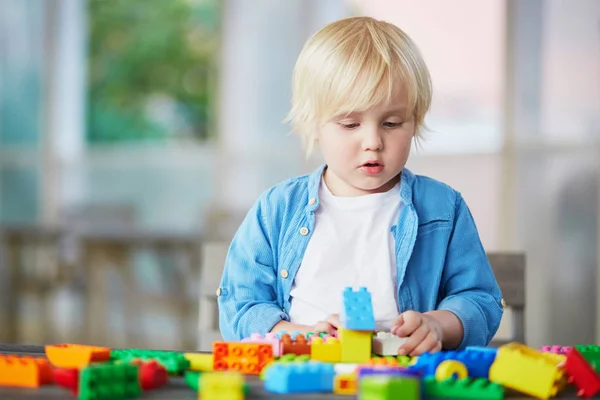 Liten pojke leker med färgglada plast konstruktion block — Stockfoto