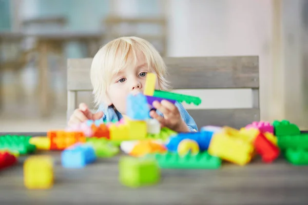 Маленький хлопчик грає з барвистими пластиковими будівельними блоками — стокове фото
