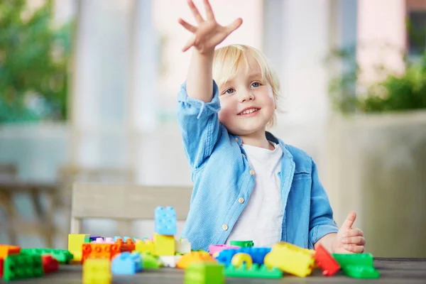 Kleiner Junge spielt mit bunten Plastikbausteinen — Stockfoto