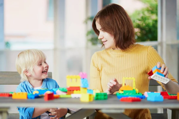 Madre jugando bloques de construcción de colores con su hijo — Foto de Stock