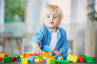 Küçük çocuk renkli plastik inşaat bloklarla oynama