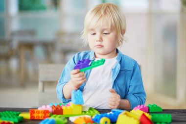 Küçük çocuk renkli plastik inşaat bloklarla oynama