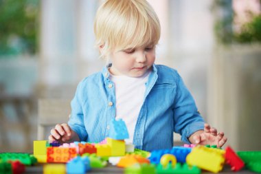Küçük çocuk renkli plastik inşaat bloklarla oynama