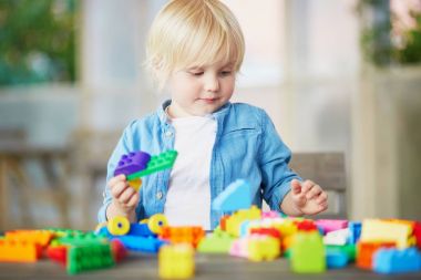 Küçük çocuk renkli plastik inşaat bloklarla oynama