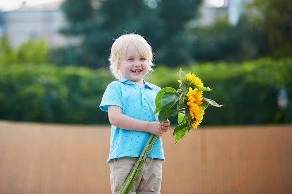 Jongetje met bos van zonnebloemen buitenshuis — Stockfoto
