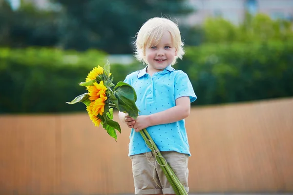 Kleiner Junge mit Sonnenblumenstrauß im Freien — Stockfoto