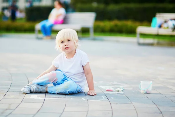 Kleiner Junge zeichnet mit Kreide auf Asphalt — Stockfoto