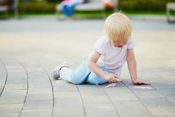 Little boy drawing with chalks on asphalt — Stock Photo, Image