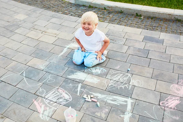 Küçük çocuk mangası ile asfalt üzerinde çizim — Stok fotoğraf