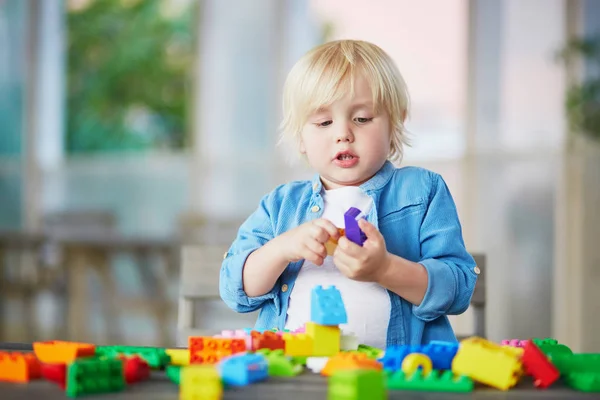 Kleine jongen spelen met kleurrijke plastic bouw blokken — Stockfoto