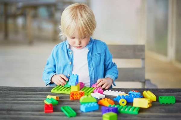 Liten pojke leker med färgglada plast konstruktion block — Stockfoto