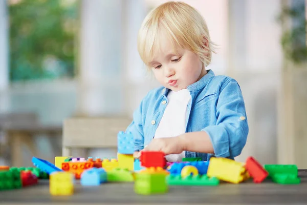 Liten pojke leker med färgglada plast konstruktion block — Stockfoto