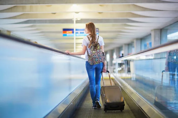 Toeristische meisje met rugzak in internationale luchthaven — Stockfoto