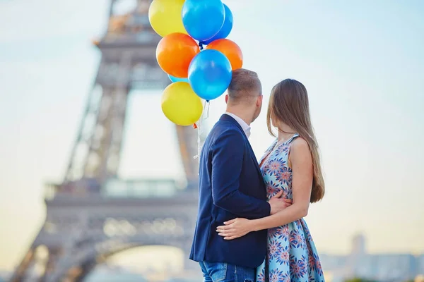 Pár s barevné balónky v blízkosti Eiffel tower — Stock fotografie