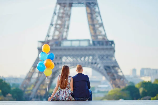 Pár s barevné balónky v blízkosti Eiffel tower — Stock fotografie