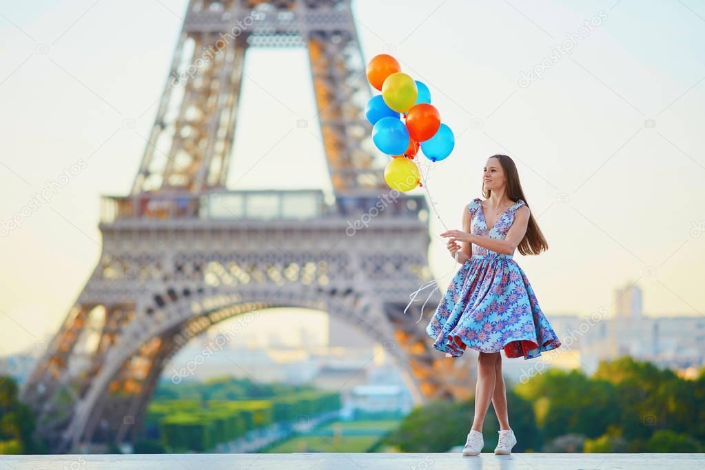 Young woman with bunch of balloons near the Eiffel tower