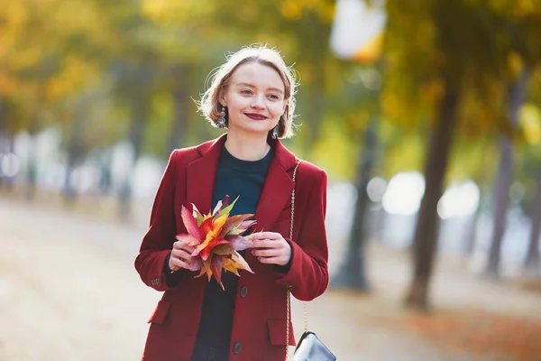 Mujer joven con racimo de hojas coloridas de otoño — Foto de Stock