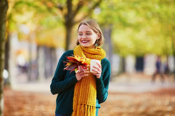 Happy young girl in yellow scarf walking in autumn park — Stock Photo, Image