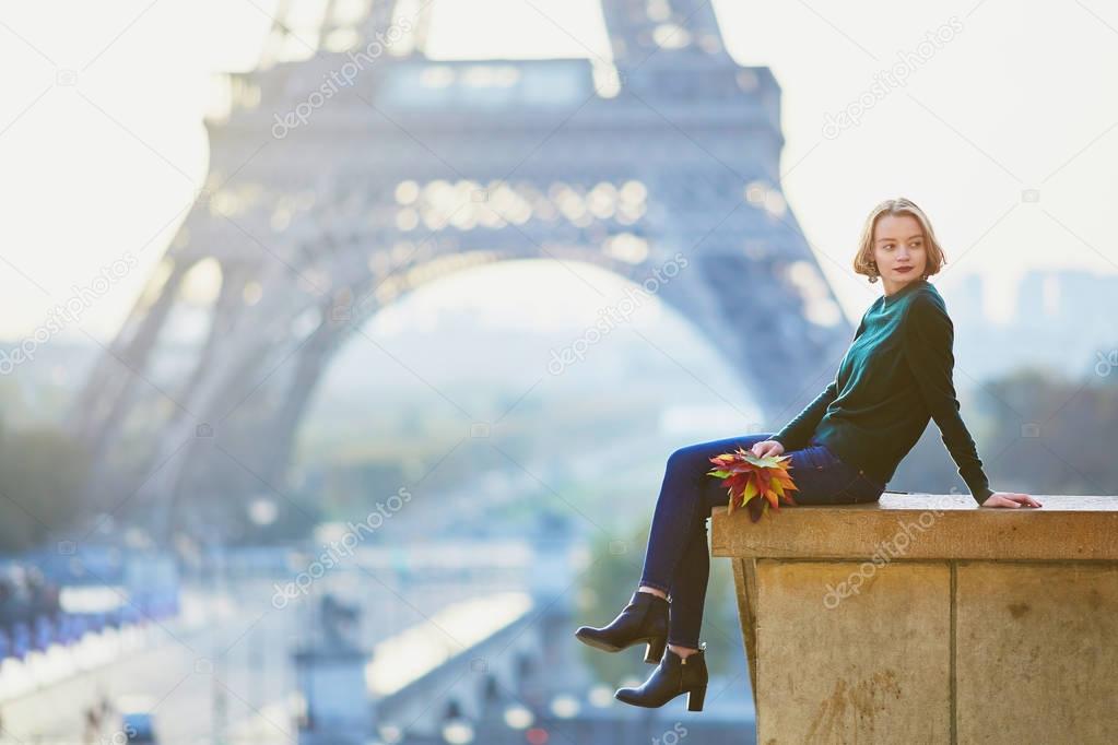 Beautiful young French woman near the Eiffel tower in Paris