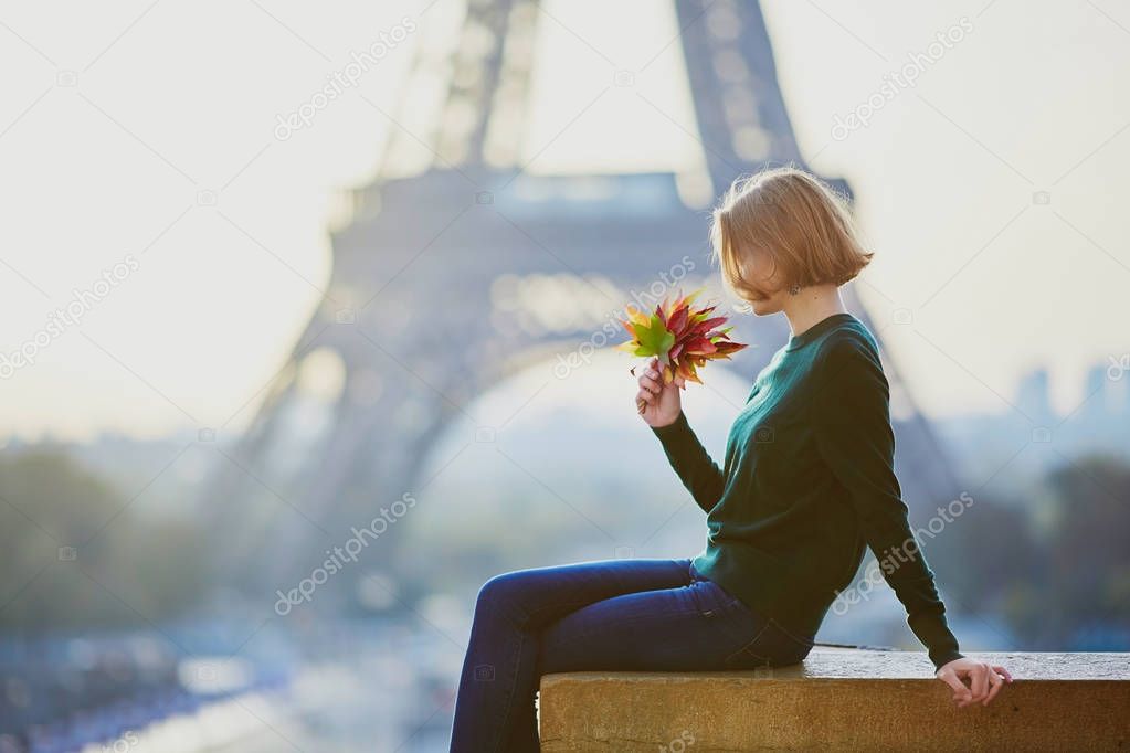 Beautiful young French woman near the Eiffel tower in Paris