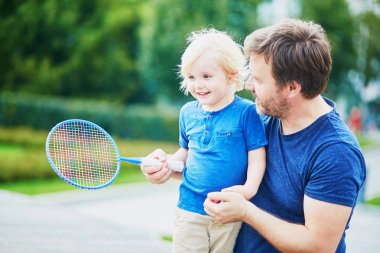 Küçük çocuk baba ile badminton oyun oynamaya
