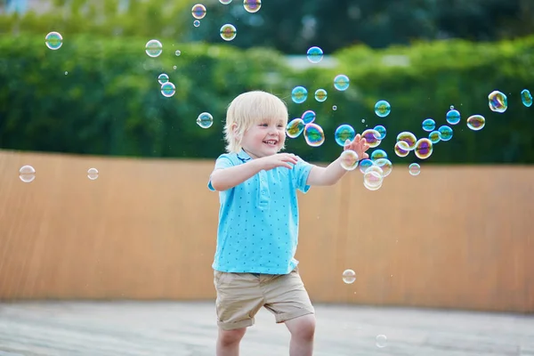 Ragazzino che gioca con le bolle all'aperto — Foto Stock