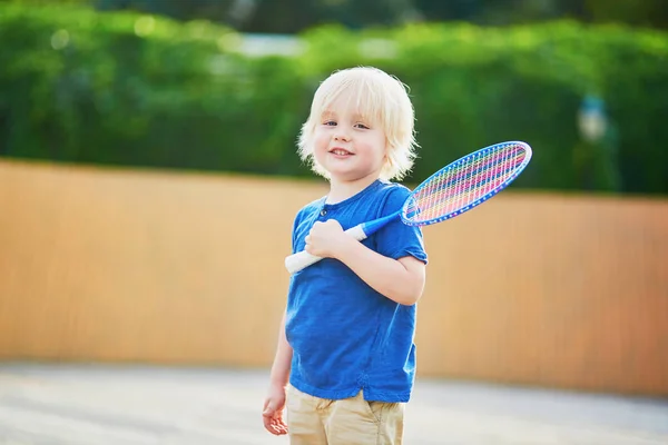 Malý chlapec hraje badminton na hřišti — Stock fotografie