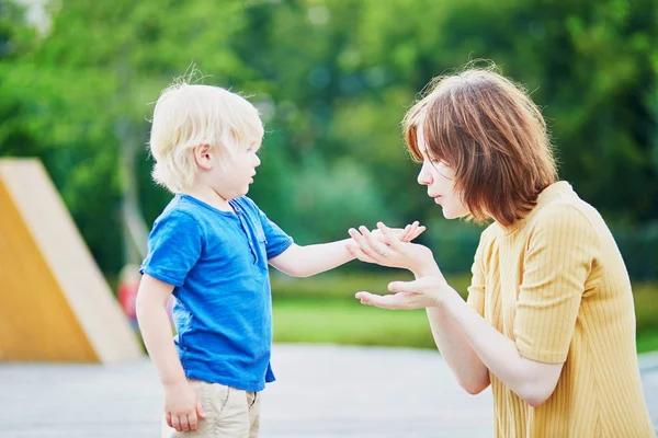 Mother comforting her son after he injured his hand — Stock Photo, Image