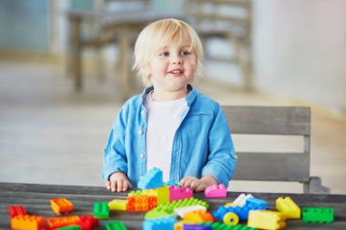 Küçük çocuk renkli plastik inşaat bloklarla oynama