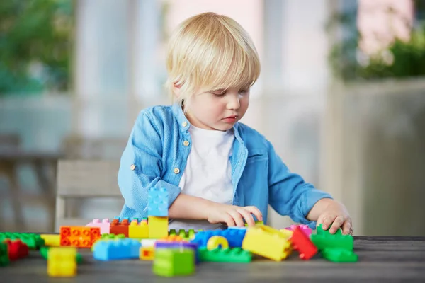 Little boy playing with colorful plastic construction blocks — Stock Photo, Image