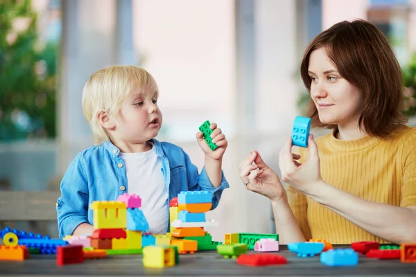 Madre jugando bloques de construcción de colores con su hijo — Foto de Stock