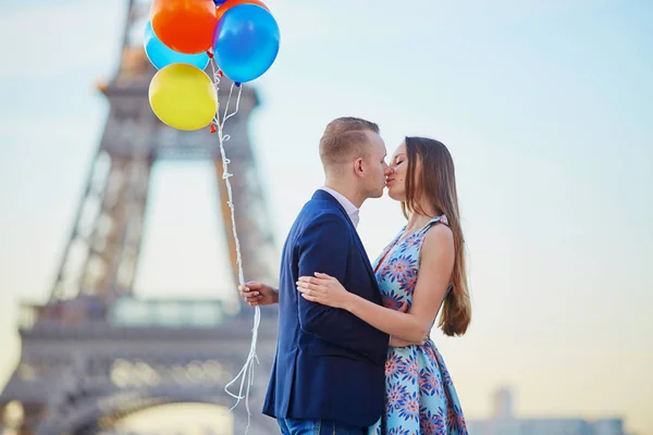 Coppia con palloncini colorati vicino alla torre Eiffel — Foto Stock