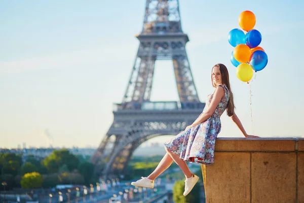 Young woman with bunch of balloons near the Eiffel tower — Stock Photo, Image