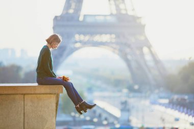 Güzel genç Fransız kadın renkli sonbahar grup ile Paris'te Eyfel Kulesinin yakınında bir sonbahar gününde bırakır
