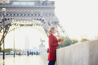 Güzel genç Fransız kadın Paris'te Eyfel Kulesinin yakınında bir Güz veya bahar gününde kahve içme