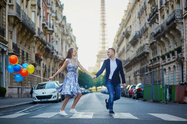 浪漫的情侣跑过街与背景在法国巴黎的埃菲尔铁塔 — 图库照片