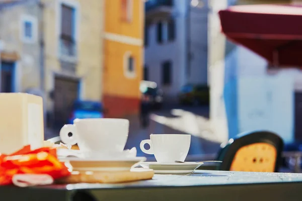 カフェや小さな典型的なサルデーニャ イタリア村のレストランのテーブルの上のコーヒー カップ — ストック写真