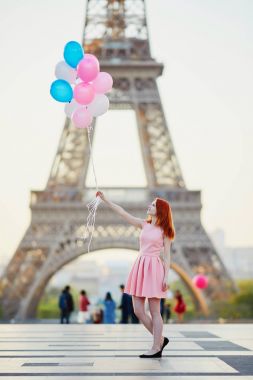 Mutlu genç kız pembe ve mavi balonlar Paris, Fransa'da Eyfel Kulesi önünde sürü