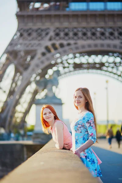 Two friends near the Eiffel tower in Paris, France; enjoying the view