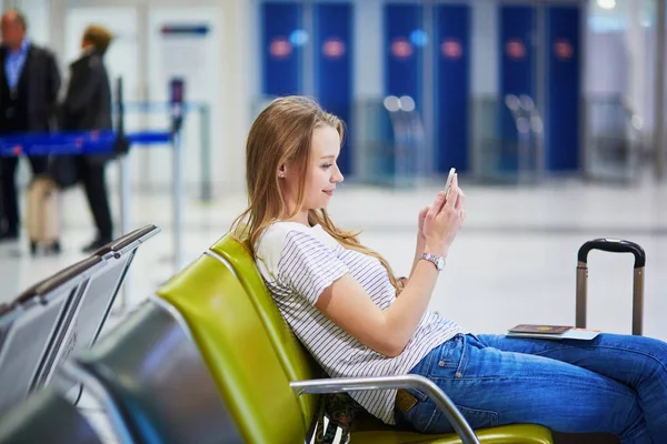 Uluslararası Havaalanında Onu Uçuş Için Beklerken Cep Telefonuyla Genç Kadın — Stok fotoğraf