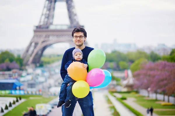 Счастливая семья из двух человек с кучей разноцветных воздушных шаров в Париже — стоковое фото