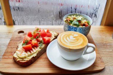 Humus ve domatesli sandviç, salata ve taze sıcak cappuccino kahve