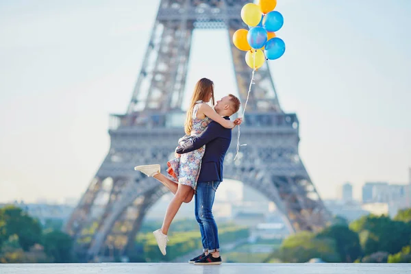 Pár s barevné balónky v blízkosti Eiffel tower — Stock fotografie