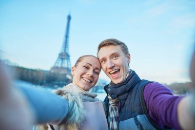 Mutlu gülümseyen çift alarak selfie Paris, Fransa'da Eyfel Kulesi ile onların hareket eden telefon ile