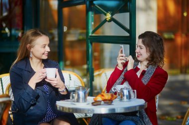 Kahve içme ve Paris, Fransa'da cep telefonunuzun açık café'de iki kız